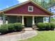 Charming bungalow with a welcoming front porch, lush landscaping, and a colorful exterior paint scheme at 1647 Walker Ave, Atlanta, GA 30337