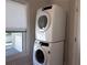 Stacked white washer and dryer unit in laundry area near window at 1647 Walker Ave, Atlanta, GA 30337