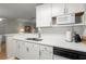 Well-equipped kitchen with white cabinets, modern appliances, and a double sink for easy meal preparation at 620 Granville Ct, Sandy Springs, GA 30328