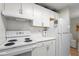 Efficient kitchen featuring white appliances and cabinets, with ample counter space for cooking convenience at 620 Granville Ct, Sandy Springs, GA 30328