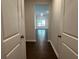 View of light filled living room from hallway with dark wood floors, neutral paint and white doors at 3908 Shelleydale Dr # 39, Powder Springs, GA 30127