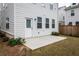 Backyard view featuring a concrete patio, lush greenery, and a door leading to the home's interior at 3739 Silvery Way, Powder Springs, GA 30127