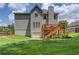 View of backyard featuring a wooden deck, stairs, grassy area, and partially fenced yard of a two-story home at 658 Eight Point Ct, Suwanee, GA 30024