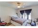 Cozy bedroom features a ceiling fan and window with blue curtains at 658 Eight Point Ct, Suwanee, GA 30024