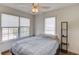 Bright bedroom with wood floors, a ceiling fan, and large windows overlooking the neighborhood at 658 Eight Point Ct, Suwanee, GA 30024