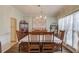 Elegant dining room with a large table and chairs, a decorative chandelier, and natural light at 658 Eight Point Ct, Suwanee, GA 30024