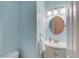 Powder room featuring a stylish vanity, round mirror, and modern lighting fixtures at 658 Eight Point Ct, Suwanee, GA 30024