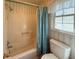 Full bath with a blue shower curtain and coordinated wallpaper and a tiled shower and modern toilet at 4402 Autumn Hill Drive, Stone Mountain, GA 30083