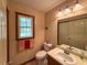 Clean bathroom featuring a single sink vanity, toilet, and a framed mirror at 4402 Autumn Hill Drive, Stone Mountain, GA 30083