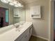Well-lit bathroom with white vanity, modern faucet, framed mirror, and bright white storage cabinet at 4402 Autumn Hill Drive, Stone Mountain, GA 30083
