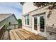 Outdoor back porch with wooden decking, brick trim, and doorway to interior at 11760 Stratham Dr, Alpharetta, GA 30009