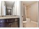 Bathroom featuring dark cabinets, granite vanity, and shower-tub combination with curtain at 11760 Stratham Dr, Alpharetta, GA 30009