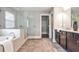 Elegant bathroom with a separate tub and shower, tiled floors, and dark wood vanity cabinets at 11760 Stratham Dr, Alpharetta, GA 30009