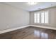 Bedroom with hardwood floors, natural light from windows with white shutters at 11760 Stratham Dr, Alpharetta, GA 30009