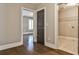 Hallway view showcasing hardwood floors and doorways to bedroom and laundry room at 11760 Stratham Dr, Alpharetta, GA 30009
