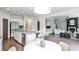 Open-concept kitchen with granite countertops, white cabinets, stainless steel appliances, and seamless flow to living area at 11760 Stratham Dr, Alpharetta, GA 30009