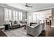Inviting living room with hardwood floors, large windows, and neutral decor, adjacent to the kitchen at 11760 Stratham Dr, Alpharetta, GA 30009