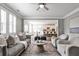 Inviting living room featuring plush seating, a ceiling fan, and an open view to the breakfast nook at 11760 Stratham Dr, Alpharetta, GA 30009
