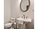 Clean and modern powder room featuring a pedestal sink and updated fixtures at 11760 Stratham Dr, Alpharetta, GA 30009