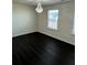 Bright bedroom featuring dark wood flooring and a stylish chandelier at 136 Paulownia Cir, Mcdonough, GA 30253