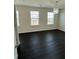 Bright bedroom featuring three windows and hardwood floors at 136 Paulownia Cir, Mcdonough, GA 30253