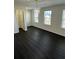 Bright bedroom featuring three windows and hardwood floors at 136 Paulownia Cir, Mcdonough, GA 30253