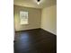Cozy bedroom with dark wood floors and a large window overlooking a serene outdoor view at 136 Paulownia Cir, Mcdonough, GA 30253