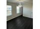 Bright bedroom featuring dark wood flooring, recessed lighting, and a decorative chandelier at 136 Paulownia Cir, Mcdonough, GA 30253