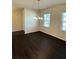 Open dining room with hardwood floors, bright windows, and modern lighting at 136 Paulownia Cir, Mcdonough, GA 30253