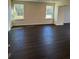 Inviting living room featuring dark wood floors, large windows, and serene neighborhood views at 136 Paulownia Cir, Mcdonough, GA 30253