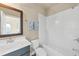 Bright bathroom with a combination bathtub and shower, featuring white tile and a dark vanity at 4311 Parkside Pl, Atlanta, GA 30342