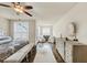 Bright bedroom with neutral walls, ceiling fan, plush rug, bench, and sitting area at 4311 Parkside Pl, Atlanta, GA 30342