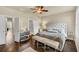 Bright bedroom with hardwood floors, neutral walls, ceiling fan, bench, and access to bathroom at 4311 Parkside Pl, Atlanta, GA 30342