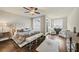 Bright bedroom with neutral walls, ceiling fan, plush rug, bench, and sitting area at 4311 Parkside Pl, Atlanta, GA 30342
