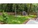 Landscaped backyard features a storage shed, mature trees, and a fenced perimeter for added privacy at 1718 Cahoon Sw St, Atlanta, GA 30310