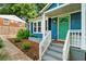 Inviting blue home featuring a charming front porch, well-kept landscaping, and a painted turquoise front door at 1718 Cahoon Sw St, Atlanta, GA 30310
