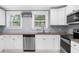 Bright kitchen showcases stainless steel appliances, granite counters, and white cabinets, offering a modern and functional space at 1718 Cahoon Sw St, Atlanta, GA 30310