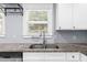 Kitchen sink area featuring granite countertops, white cabinets, stainless steel faucet and appliance, creating an inviting space at 1718 Cahoon Sw St, Atlanta, GA 30310