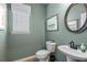 Stylish bathroom featuring a decorative mirror, toilet, sink, and window at 48 Calla Dr, Douglasville, GA 30134