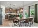 Open dining area with wood table, seating for six, modern light fixture, and beautiful eat in kitchen at 48 Calla Dr, Douglasville, GA 30134