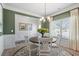 Dining area with a round wooden table with white chairs, chandelier, and large windows overlooking the outdoors at 48 Calla Dr, Douglasville, GA 30134