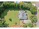 Aerial view of a home with a manicured lawn, driveway, and mature trees at 207 Breckenridge Ct, Canton, GA 30115