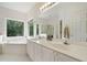 Bright bathroom featuring a soaking tub, double vanity, and large windows offering a serene view at 207 Breckenridge Ct, Canton, GA 30115