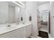 Well-lit bathroom featuring double sinks, a large mirror, and a shower with decorative curtain at 207 Breckenridge Ct, Canton, GA 30115