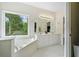 Elegant bathroom with double vanity, a jacuzzi tub, and ample natural light from a large window at 207 Breckenridge Ct, Canton, GA 30115