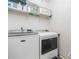Well-equipped laundry room featuring a washer, dryer, and shelving for storage at 207 Breckenridge Ct, Canton, GA 30115
