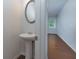 Quaint half bathroom featuring a pedestal sink and a view into a room with a window at 3016 Creekside Overlook Way, Austell, GA 30168