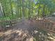 Wooden back deck with a railing that overlooks the backyard surrounded by lush trees at 2251 Stag Run Run, Suwanee, GA 30024