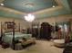 Spacious main bedroom features a decorative ceiling with chandelier, sitting area and coordinating colors at 5523 Bahia Mar Cir, Stone Mountain, GA 30087