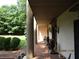 Covered porch with brick flooring, decorative columns, and cozy seating area at 5523 Bahia Mar Cir, Stone Mountain, GA 30087